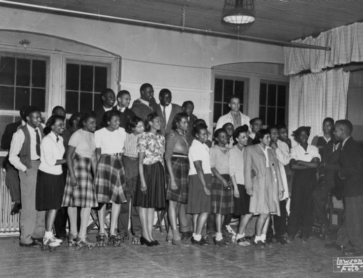A group of young people, some with roller skates.