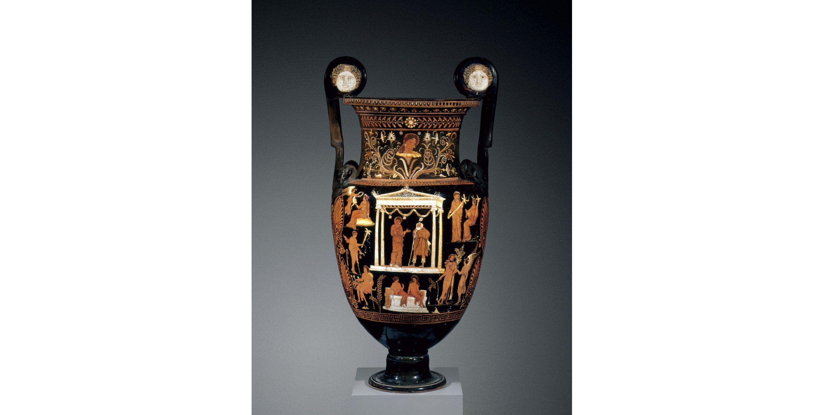 Image of a red-figure vase depiciting Jason and Medea standing in a temple structure with their childen illustrated below sitting on a couch.