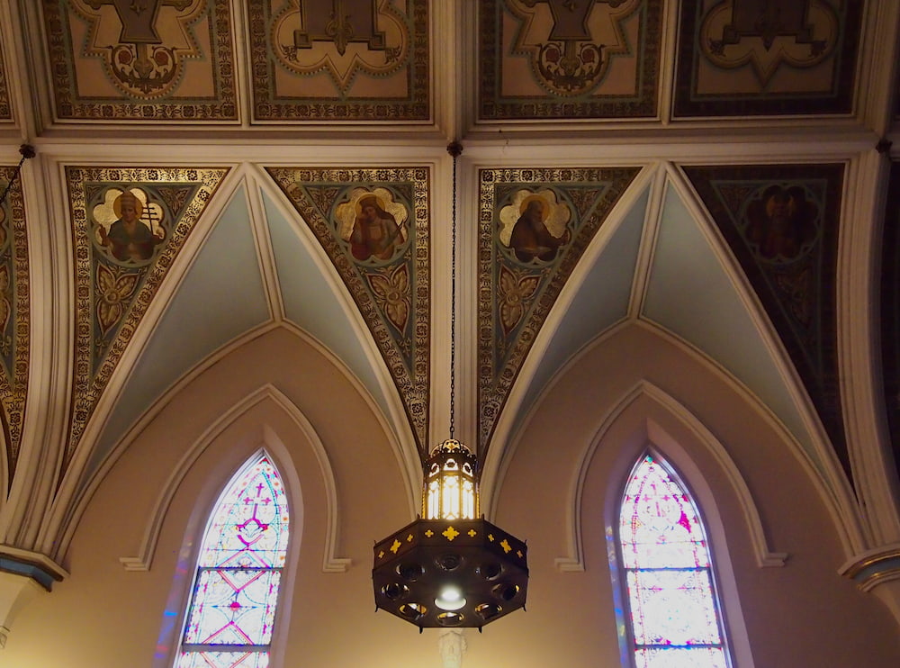 Two windows in a church with a view of paintings on the ceiling